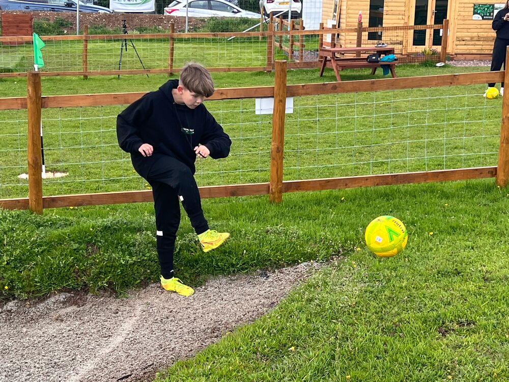 A young Footgolf Devon League player kicking a football