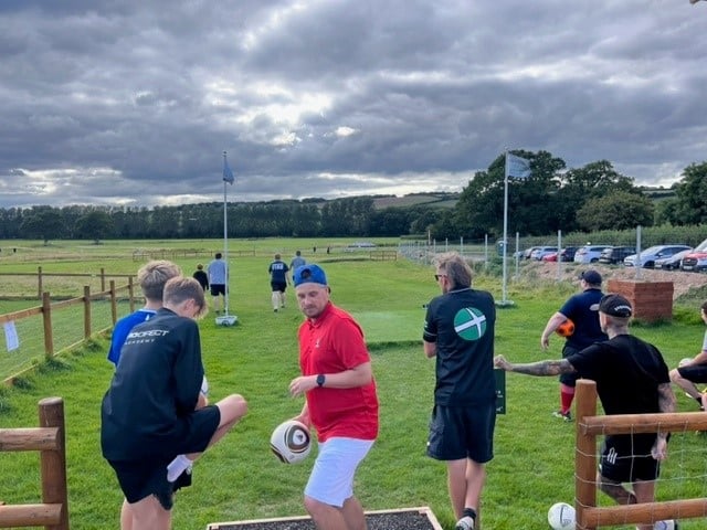 six boys getting ready to play Footgolf together at the starting line